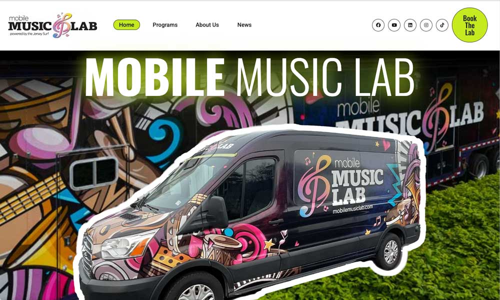 Mobile Music Lab website hero featuring a die-cut photo of the lab's van wrapped in colorful music-themed graphics, set over a close-up of the wrap artwork, with a lime “Book The Lab” button
